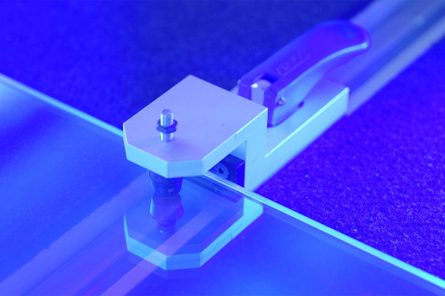 Morsa che tiene una lastra di vetro illuminata da led blu